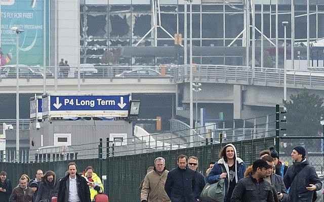 La gente se aleja de las ventanas rotas en el aeropuerto de Zaventem en Bruselas después de una explosión el martes 22 de marzo de 2016. (AP Photo / Geert Vanden Wijngaert)