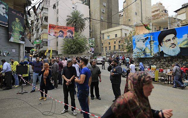 Carteles que muestran al líder de Hezbolá, Hassan Nasrallah, frente a una mesa de votación durante las elecciones parlamentarias del Líbano, en Beirut, Líbano, el 6 de mayo de 2018. (AP Photo / Hassan Ammar)