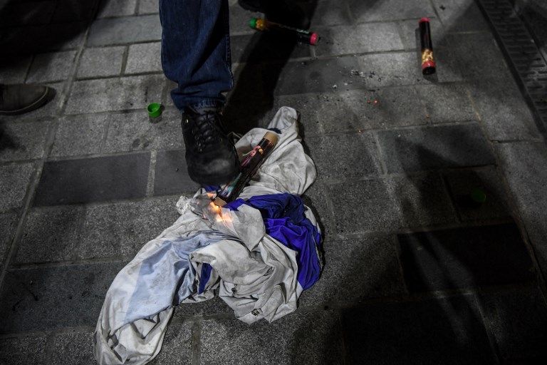 Un hombre pisa una bandera israelí después de prenderle fuego mientras participa en una marcha de protesta en Estambul el 14 de mayo de 2018 para protestar contra la decisión del presidente estadounidense Donald Trump de trasladar la embajada de Estados Unidos desde Tel Aviv a Jerusalén. (AFP Photo / Ozan Kose)