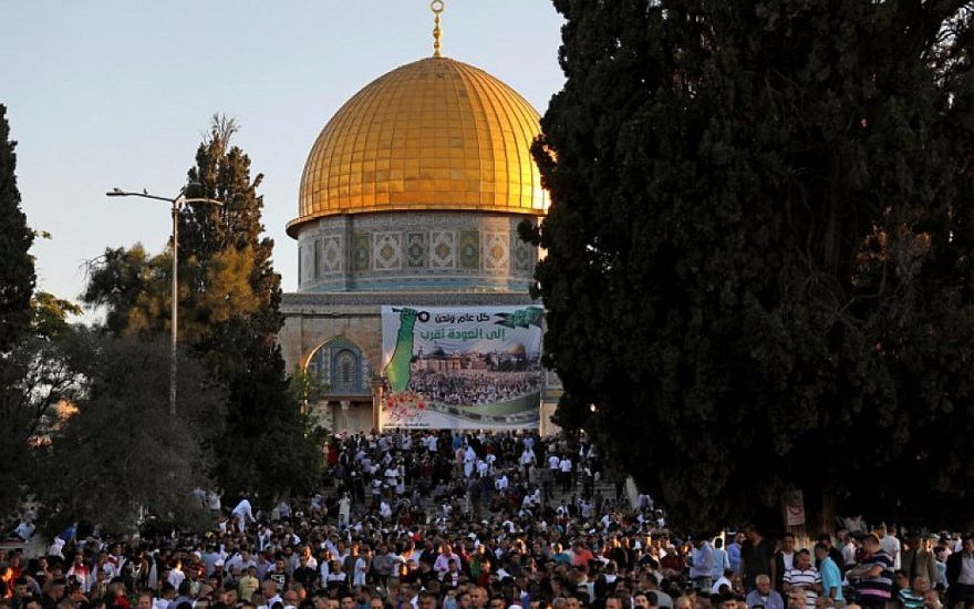 Los musulmanes palestinos realizan la oración de Eid al-Fitr en la mañana cerca de la Cúpula de la Roca en el complejo de la Mezquita Al-Aqsa, el tercer lugar más sagrado del Islam, en la Ciudad Vieja de Jerusalén el 15 de junio de 2018. (AFP / Ahmad Gharabli)