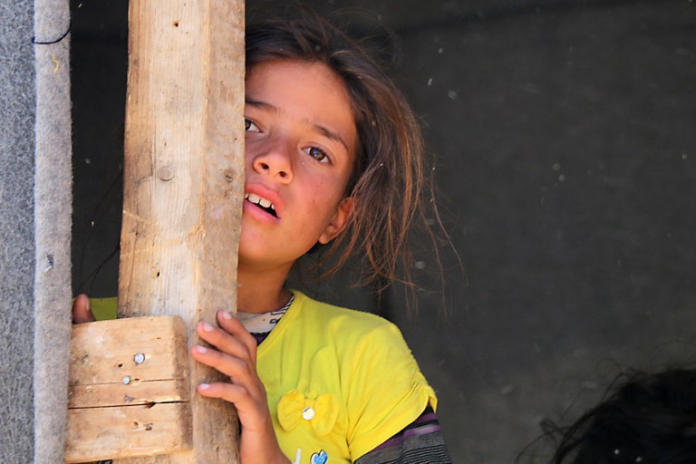 Una niña siria desplazada de Daraa se encuentra en un campamento improvisado en Quneitra, al sudoeste de Siria, cerca de la frontera con Israel, el 22 de junio de 2018. (AFP PHOTO / Ahmad al-Msalam)