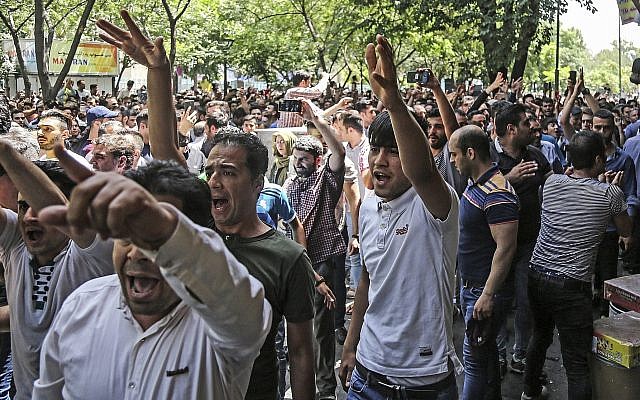 Un grupo de manifestantes grita consignas en el antiguo gran bazar en Teherán, Irán, el lunes 25 de junio de 2018. Los manifestantes en la capital iraní invadieron su histórico Gran Bazar el lunes, informaron agencias de noticias, y forzaron a los tenderos a cerrar sus puestos aparentemente enojados. sobre la economía problemática de la República Islámica, meses después de manifestaciones similares sacudieron el país. (Agencia de noticias laborales iraní a través de AP)