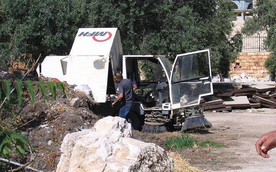 En abril de 2014, un limpiador de calles de Waqf vierte tierra en la pila de tierra de las excavaciones en el Monte del Templo / Compuesto Al-Aqsa. (Cortesía del Comité Público para la Prevención de la Destrucción de Antigüedades en el Monte del Templo)
