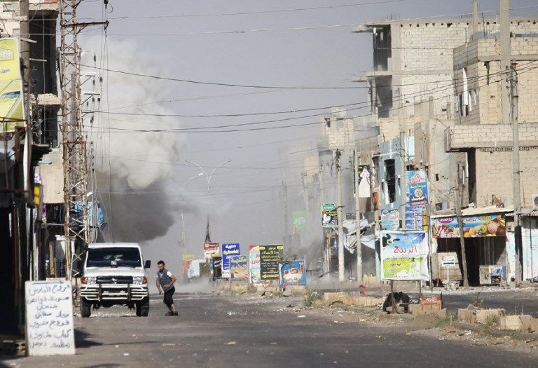 Una fotografía tomada el 21 de junio de 2018 muestra a personas huyendo mientras se alzan las columnas de humo del bombardeo del régimen en Al-Hirak en el campo oriental de la provincia de Daraa, en el sur de Siria. (AFP / Mohamad ABAZEED)