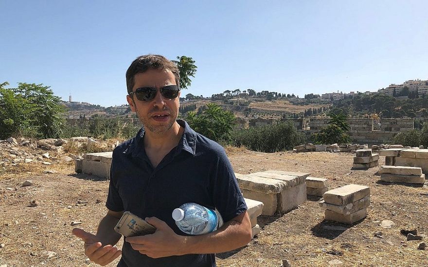 El arqueólogo Zachi Dvira se para frente a lo que dijo que eran mesas improvisadas y bancos creados a partir de losas de piedra encontradas en un montículo de tierra antigua en el Monte del Templo, el 18 de junio de 2018. (Amanda Borschel-Dan / Times of Israel)