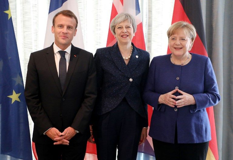 El presidente francés Emmanuel Macron, izquierda, la primera ministra británica Theresa May, y la canciller alemana Angela Merkel sonríen mientras posan para las fotos al comienzo de una cumbre UE-Occidente de los Balcanes en Sofía, el 17 de mayo de 2018. (Ludovic MARIN / AFP)