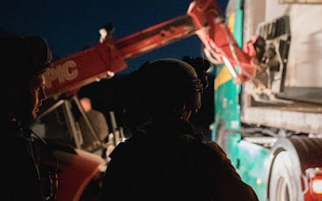 Los tractores cargan suministros humanitarios de las FDI en un camión que se envía a los refugiados sirios en campamentos de campaña en el suroeste de Siria, el 28 de junio de 2018 en los Altos del Golán. (Unidad del Portavoz de las FDI)