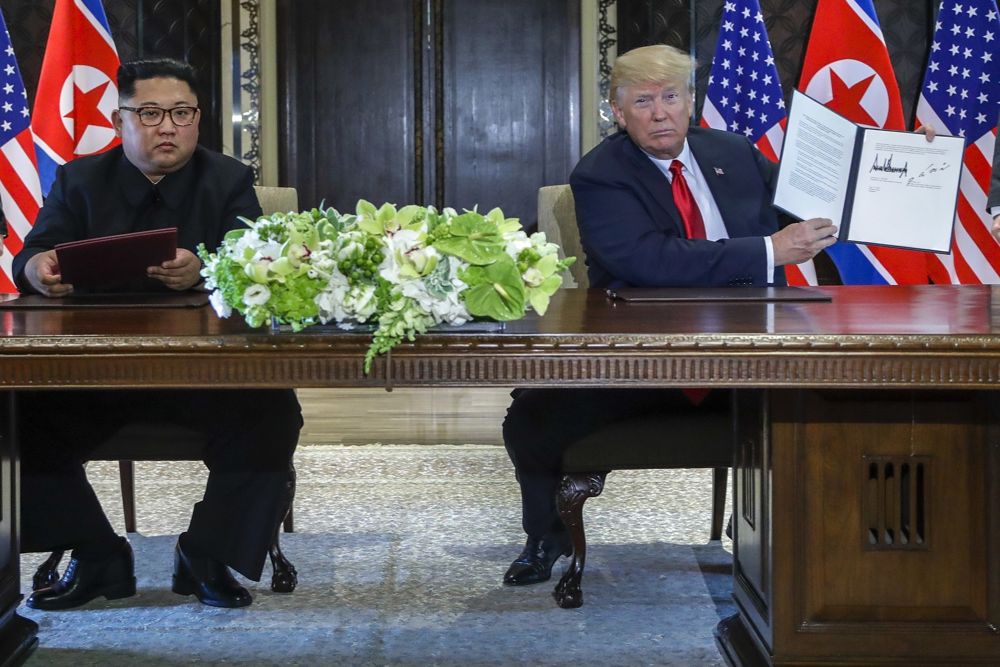 El presidente estadounidense, Donald Trump, sostiene el documento que él y el líder norcoreano Kim Jong Un acababan de firmar en el complejo Capella en la isla Sentosa, el 12 de junio de 2018 en Singapur. (AP Photo / Evan Vucci)