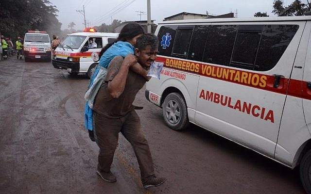 Personas huyen de la aldea El Rodeo, departamento de Escuintla, a 35 km al sur de la ciudad de Guatemala, luego de la erupción del volcán Fuego el 3 de junio de 2018. (NOE PEREZ / AFP)