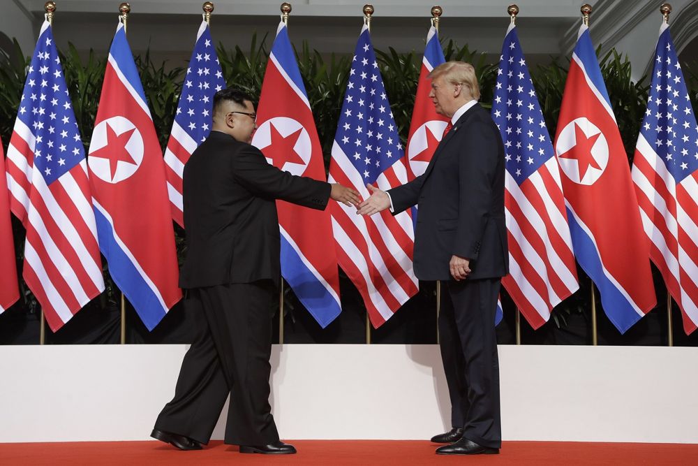 El presidente de los Estados Unidos, Donald Trump, llega a estrechar la mano del líder de Corea del Norte, Kim Jong Un, en el complejo de Capella en la isla de Sentosa, el 12 de junio de 2018, en Singapur. (AP Photo / Evan Vucci)