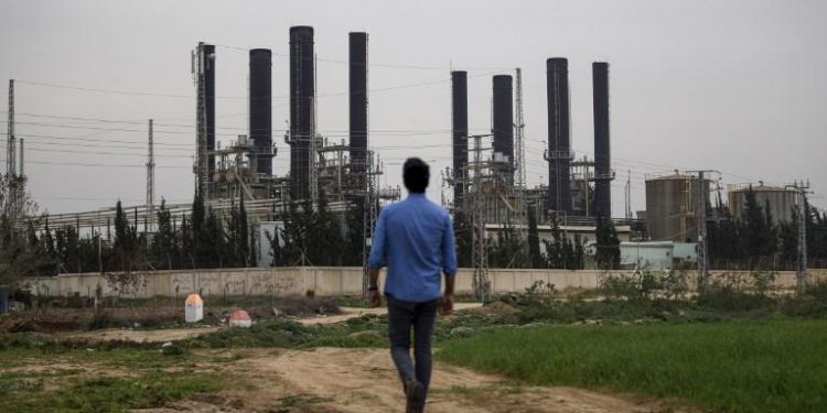 Un joven palestino camina hacia la única planta de electricidad de la franja de Gaza, que proporciona una quinta parte de las necesidades energéticas de la región, después de que dejó de funcionar a la medianoche de la noche anterior debido a la falta de combustible según funcionarios locales, el 15 de febrero de 2018. (MOHAMMED ABED / AFP)