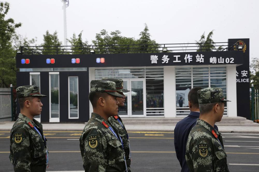 Soldados vigilan cerca de una estación de policía en el centro de medios de la cumbre de la Organización de Cooperación de Shanghai (OCS) en Qingdao, provincia de Shandong, este de China, el sábado 9 de junio de 2018. (AP Photo / Dake Kang)