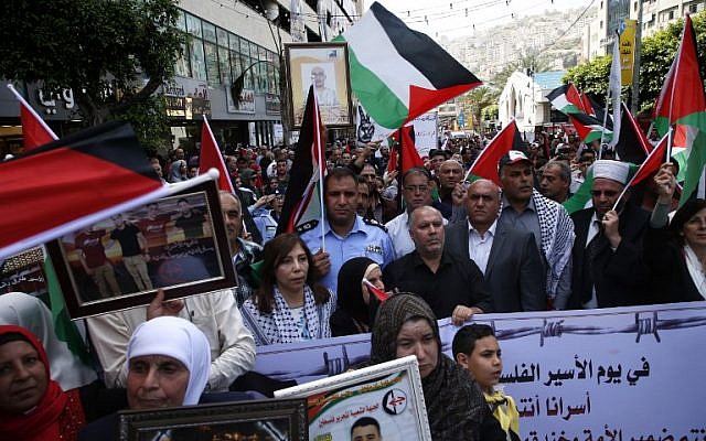 Los palestinos sostienen retratos de familiares encarcelados en prisiones israelíes mientras protestan para exigir su liberación durante una manifestación para conmemorar el Día del Preso en la ciudad de Nablus, al norte de Cisjordania, el 17 de abril de 2018. (AFP PHOTO / JAAFAR ASHTIYEH)