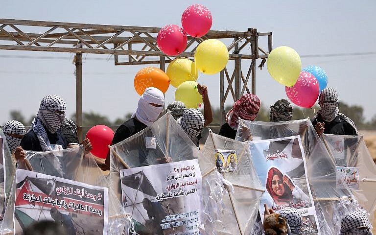 Los palestinos cargan cometas y globos con material inflamable para volar hacia Israel, en la frontera entre Israel y Gaza en al-Bureij, en el centro de la Franja de Gaza, el 14 de junio de 2018. (AFP Photo / Mahmud Hams