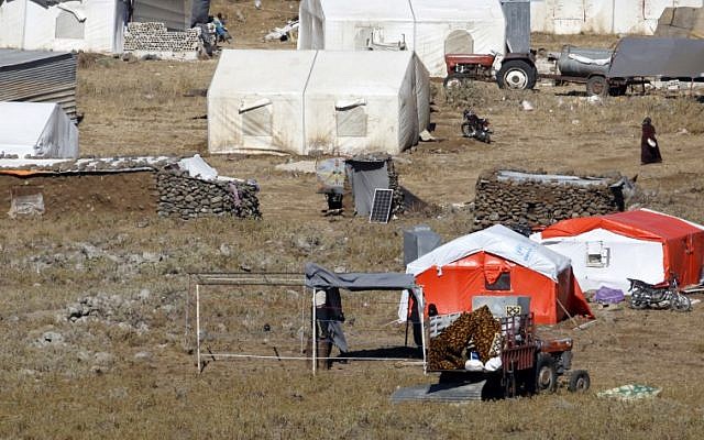 Una fotografía tomada el 30 de junio de 2018, desde los Altos del Golán muestra a los refugiados construyendo una nueva tienda de campaña en un campamento para sirios desplazados cerca de la aldea siria de Burayqah en la provincia sureña de Quneitra. (AFP / JALAA MAREY)