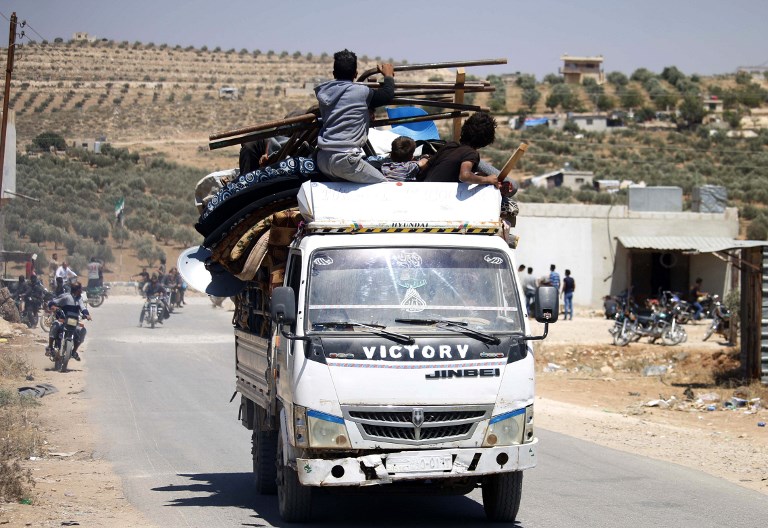 Los sirios huyen de las áreas controladas por los rebeldes de la ciudad de Daraa durante los ataques aéreos de las fuerzas del régimen sirio el 30 de junio de 2018. (AFP / Mohamad ABAZEED)