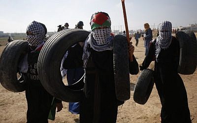 Los palestinos se preparan para quemar neumáticos durante los enfrentamientos semanales de 'Marcha del Retorno' en la frontera de Gaza, al este de la ciudad de Gaza, el 6 de julio de 2018. (AFP Photo / Said Khatib)