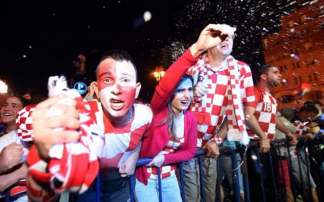 Los seguidores de Croacia celebran después de un gol mientras ven en una pantalla gigante el partido de fútbol semifinal de la Copa Mundial Rusia 2018 entre Croacia e Inglaterra, en la plaza principal de Zagreb el 11 de julio de 2018. (AFP PHOTO / Denis Lovrovic)