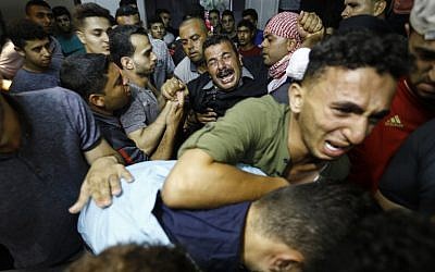 Los familiares palestinos reaccionan cuando llegan a la morgue del hospital al-Shifa en la ciudad de Gaza, donde llevaron el cadáver de Mohammed Badwan después de que las fuerzas israelíes lo mataron a tiros durante las protestas en la frontera al este de la ciudad de Gaza. (AFP PHOTO / ANAS BABA)