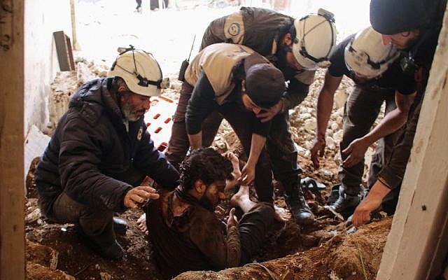 Los miembros de los voluntarios de la Defensa Civil siria, también conocidos como Cascos Blancos, sacaron a una víctima de los escombros de su casa, luego de un ataque aéreo de las fuerzas gubernamentales en una zona controlada por los rebeldes en la ciudad siria sureña de Daraa, el 8 de abril. 2017. (Mohamad ABAZEED / AFP)