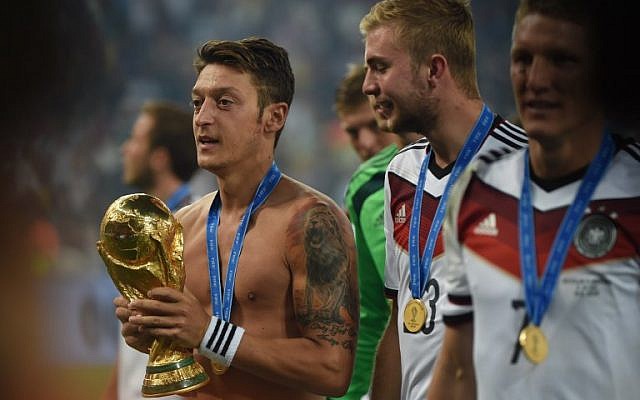 El centrocampista alemán Mesut Ozil, a la izquierda, celebra el trofeo de la Copa del Mundo después del partido de fútbol final entre Alemania y Argentina para la Copa Mundial de la FIFA en el Estadio Maracaná en Río de Janeiro, 13 de julio de 2014. (Patrik STOLLARZ / AFP)