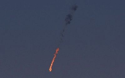 Un avión de combate sirio se ve en llamas después de que fue alcanzado por el ejército israelí sobre los Altos del Golán el 23 de septiembre de 2014. (Crédito de la foto: AFP / JALAA MAREY)