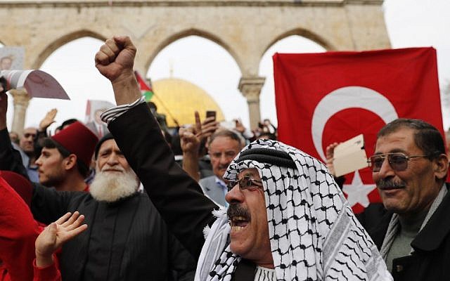 Los fieles musulmanes sostienen banderas palestinas y turcas después de la oración del viernes al mediodía en el complejo de la mezquita Al-Aqsa de la Ciudad Vieja de Jerusalén en el Monte del Templo, 22 de diciembre de 2017. (AFP Photo / Ahmad Gharabli)