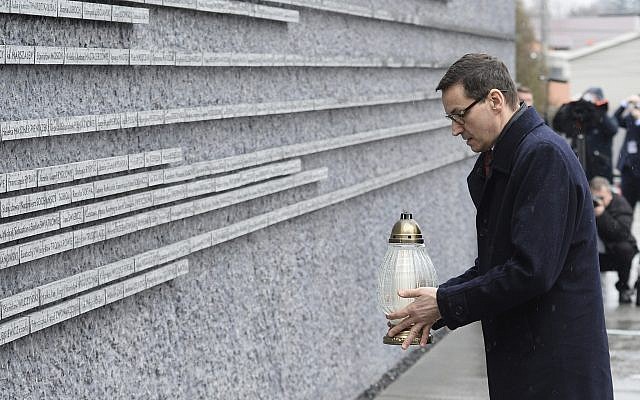 El primer ministro polaco Mateusz Morawiecki coloca una vela en una pared conmemorativa con los nombres de algunos de los polacos que salvaron judíos durante el Holocausto, en el Museo de la Familia Ulma que rescató a los judíos durante la Segunda Guerra Mundial, en Markowa, Polonia, el viernes 2 de febrero. 2018. (AP / Alik Keplicz)