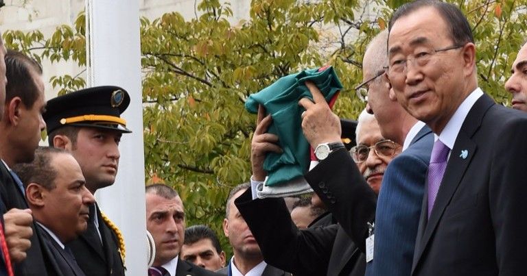 El presidente de la Autoridad Palestina, Mahmoud Abbas, iza la bandera de la Gran Revuelta Árabe en su versión de la Autoridad Palestina mientras el secretario general de la ONU de entonces, Ban Ki-moon observa durante una ceremonia en el jardín de rosas de la sede de la ONU en Nueva York el 30 de septiembre de 2015. (AFP PHOTO / TIMOTHY A. CLARY)