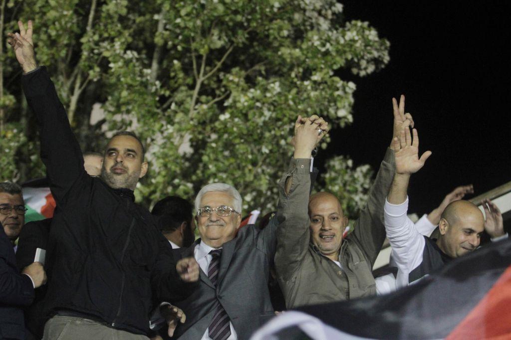 El presidente de la Autoridad Palestina, Mahmoud Abbas, segundo desde la izquierda, saluda con terroristas liberados provenientes de cárceles israelíes durante las celebraciones en la sede de Abbas en la ciudad de Ramallah, 30 de octubre de 2013. (Issam Rimawi / Flash 90)