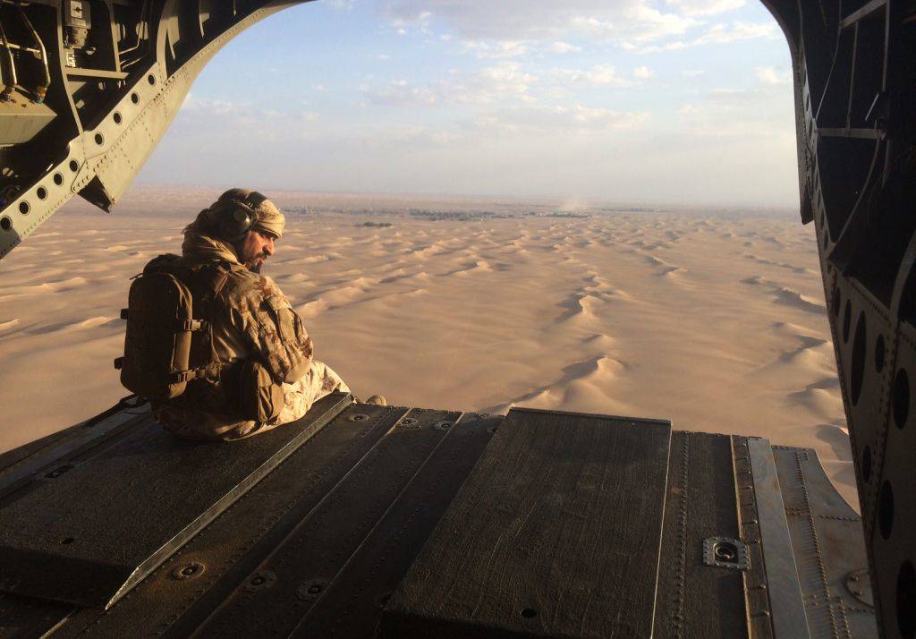 Un artillero emiratí observa el fuego enemigo desde la puerta trasera de un helicóptero militar Chinook de los Emiratos Árabes Unidos sobrevolando Yemen. (AP Photo / Adam Schreck, Archivo)