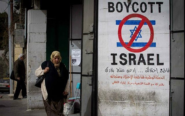 Una mujer palestina camina junto a un letrero que llama a boicotear a Israel en la ciudad cisjordana de Belén el 11 de febrero de 2015. (Miriam Alster / Flash 90)