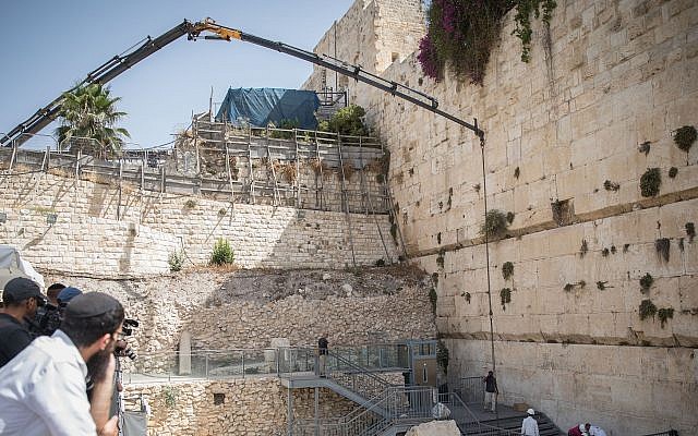 Los trabajadores unen una grúa a un gran trozo de piedra que se desprendió del Muro de las Lamentaciones en la Ciudad Vieja de Jerusalén, en la sección de oración mixta, el 25 de julio de 2018. (Hadas Parush / Flash90)