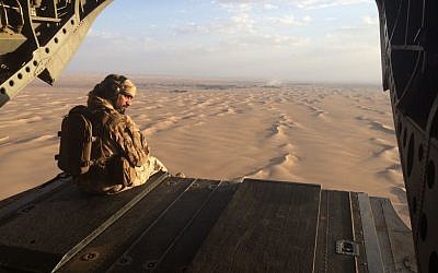 Un artillero emiratí observa el fuego enemigo desde la puerta trasera de un helicóptero militar Chinook de los Emiratos Árabes Unidos sobrevolando Yemen. (AP Photo / Adam Schreck, Archivo)