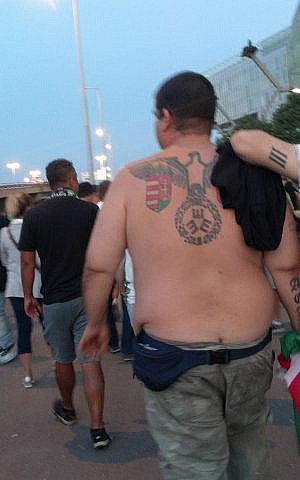 Un hombre con un tatuaje en la espalda que se asemeja al Reichsadler, el símbolo oficial de la Alemania nazi, fuera del Groupama Arena en Budapest, después de un partido entre el club local Ferencvaros Torna y el Maccabi Tel Aviv. (Yaakov Schwartz / Times of Israel)