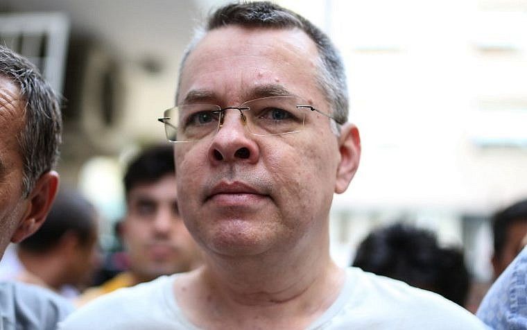 El pastor estadounidense Andrew Brunson escoltado por agentes de policía vestidos de civil en Turquía llega a su casa el 25 de julio de 2018 en Izmir. (FOTO DE AFP)