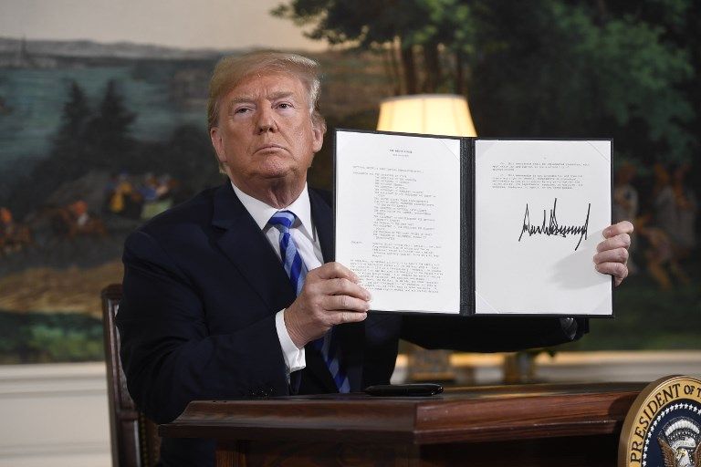 El presidente estadounidense Donald Trump firma un documento que restablece las sanciones contra Irán después de anunciar la retirada de Estados Unidos del acuerdo nuclear de Irán, en la sala de recepción diplomática en la Casa Blanca en Washington, DC, el 8 de mayo de 2018. (AFP PHOTO / SAUL LOEB)