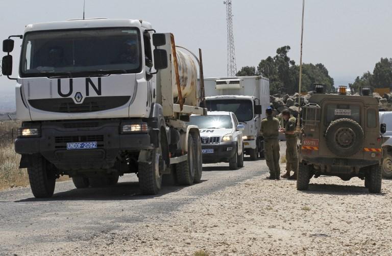 Una foto tomada el 4 de julio de 2018 muestra los vehículos de la ONU que cruzan desde Siria hacia los Altos del Golán israelí. (AFP / Jalaa Marey)