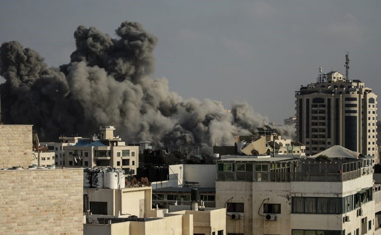 El humo se eleva sobre los edificios durante un ataque aéreo israelí en la ciudad de Gaza el 14 de julio de 2018. (AFP PHOTO / MAHMUD HAMS)