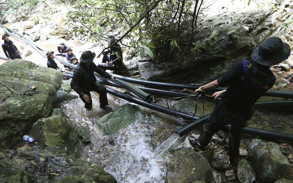 Soldados tailandeses arrastran pipas de agua para bombear agua a un complejo de cuevas donde 12 niños y su entrenador de fútbol están atrapados en el norte de Tailandia, 7 de julio de 2018 (AP Photo / Sakchai Lalit)