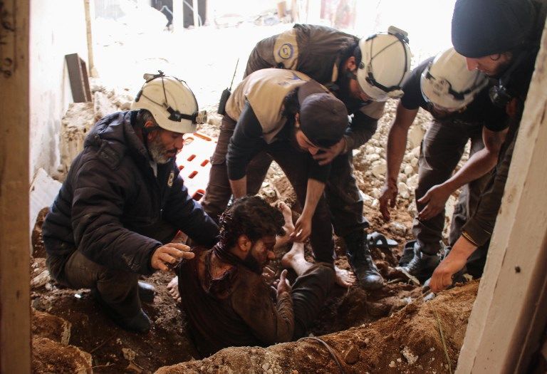 Los miembros de los voluntarios de la Defensa Civil siria, también conocidos como Cascos Blancos, sacaron a una víctima de los escombros de su casa, luego de un ataque aéreo de las fuerzas gubernamentales en una zona controlada por los rebeldes en la ciudad siria sureña de Daraa, el 8 de abril. 2017. (Mohamad ABAZEED / AFP)