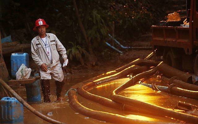 Un socorrista baja por unos escalones llenos de barro a la entrada de un complejo de cuevas donde 12 miembros del equipo de fútbol y su entrenador desaparecieron el 2 de julio de 2018 en Mae Sai, provincia de Chiang Rai, en el norte de Tailandia. (Foto AP / Sakchai Lalit)