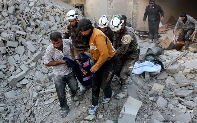 Voluntarios de la defensa civil siria, conocidos como los Cascos Blancos, evacuan a una víctima de los escombros de un edificio después de los ataques aéreos informados en el distrito de al-Hamra controlado por los rebeldes de Alepo el 20 de noviembre de 2016. / AFP PHOTO / THAER MOHAMMED