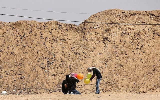 Ilustrativo: los habitantes de Gaza cargan globos con material inflamable para volar hacia Israel, en la frontera entre Israel y Gaza en al-Bureij, en el centro de la Franja de Gaza el 14 de junio de 2018. (AFP / Hams Mahmud)