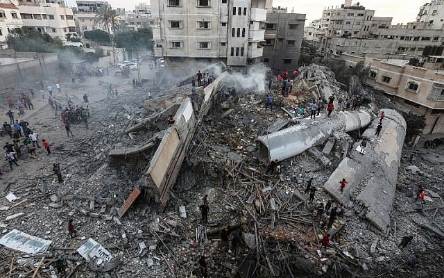 Una fotografía tomada el 9 de agosto de 2018 muestra a personas inspeccionando los escombros de un edificio atacado por la Fuerza Aérea israelí en respuesta a un ataque con cohetes que azotó el sur de Israel el 9 de agosto de 2018. (AFP Photo / Mahmud Hams)