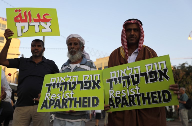 Los israelíes árabes portan pancartas durante una manifestación para protestar contra la ley del Estado-nación en Tel Aviv el 11 de agosto de 2018. (AFP / Ahmad GHARABLI)