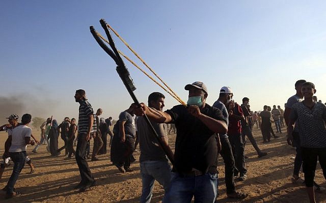 Un manifestante palestino utiliza un tirachinas para arrojar piedras a las fuerzas israelíes durante una manifestación en la frontera entre Israel y Gaza, al este de Khan Yunis en el sur de la Franja de Gaza el 24 de agosto de 2018. (AFP PHOTO / SAID KHATIB)