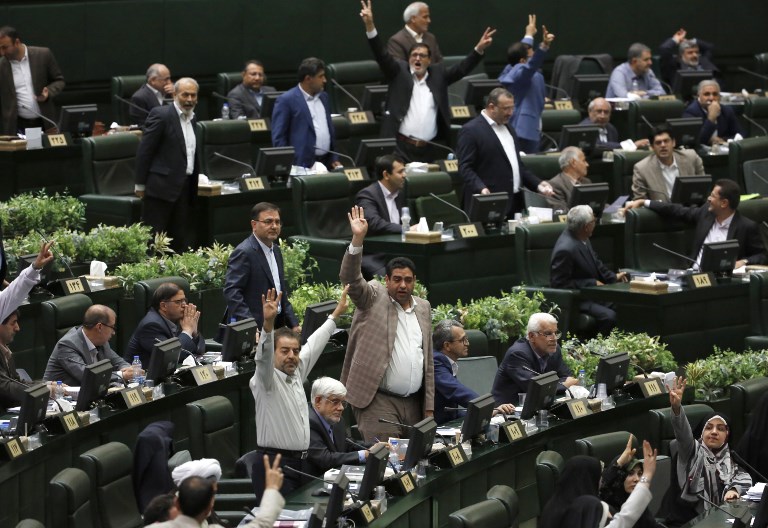 Los miembros del Parlamento iraní hacen gestos mientras el presidente Hassan Rouhani (no en la foto) habla en la capital, Teherán, el 28 de agosto de 2018. (AFP PHOTO / ATTA KENARE)