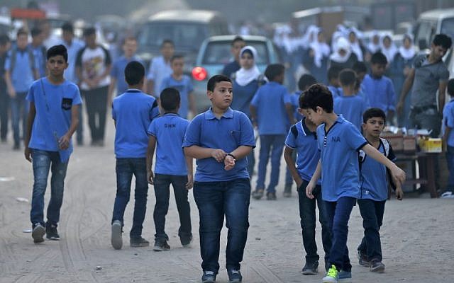 Los alumnos se reúnen frente a una escuela administrada por la Agencia de las Naciones Unidas para los Refugiados Palestinos (UNRWA) en la ciudad de Gaza el 29 de agosto de 2018, el primer día de clases después de las vacaciones de verano. (AFP PHOTO / Mahmud Hams)