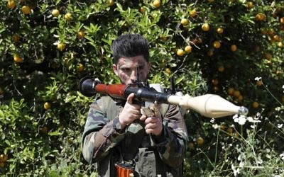 Un combatiente de Hezbolá es visto de pie en atención en un campo naranja cerca de la ciudad de Naqura en la frontera libanesa-israelí el 20 de abril de 2017. (AFP PHOTO / JOSEPH EID)